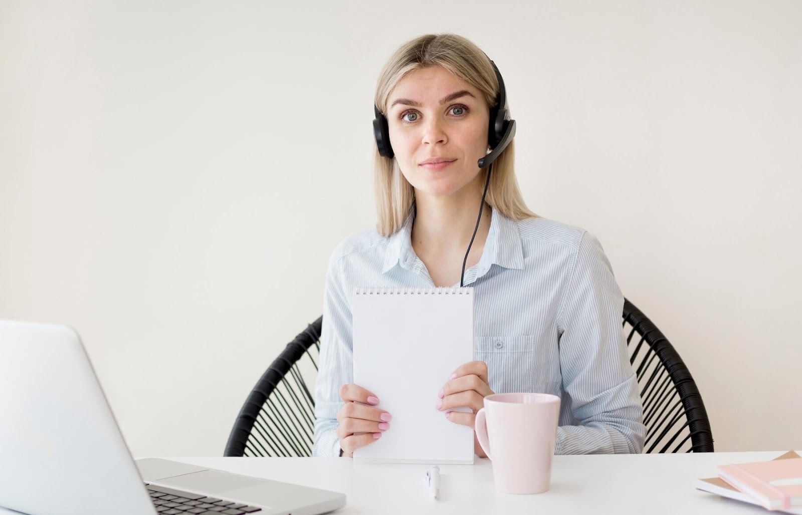 A girl wearing a headset sits in front of a laptop