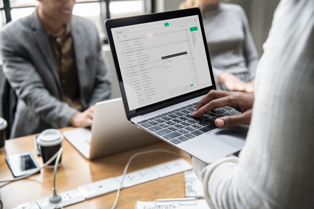 Man holding laptop with open email