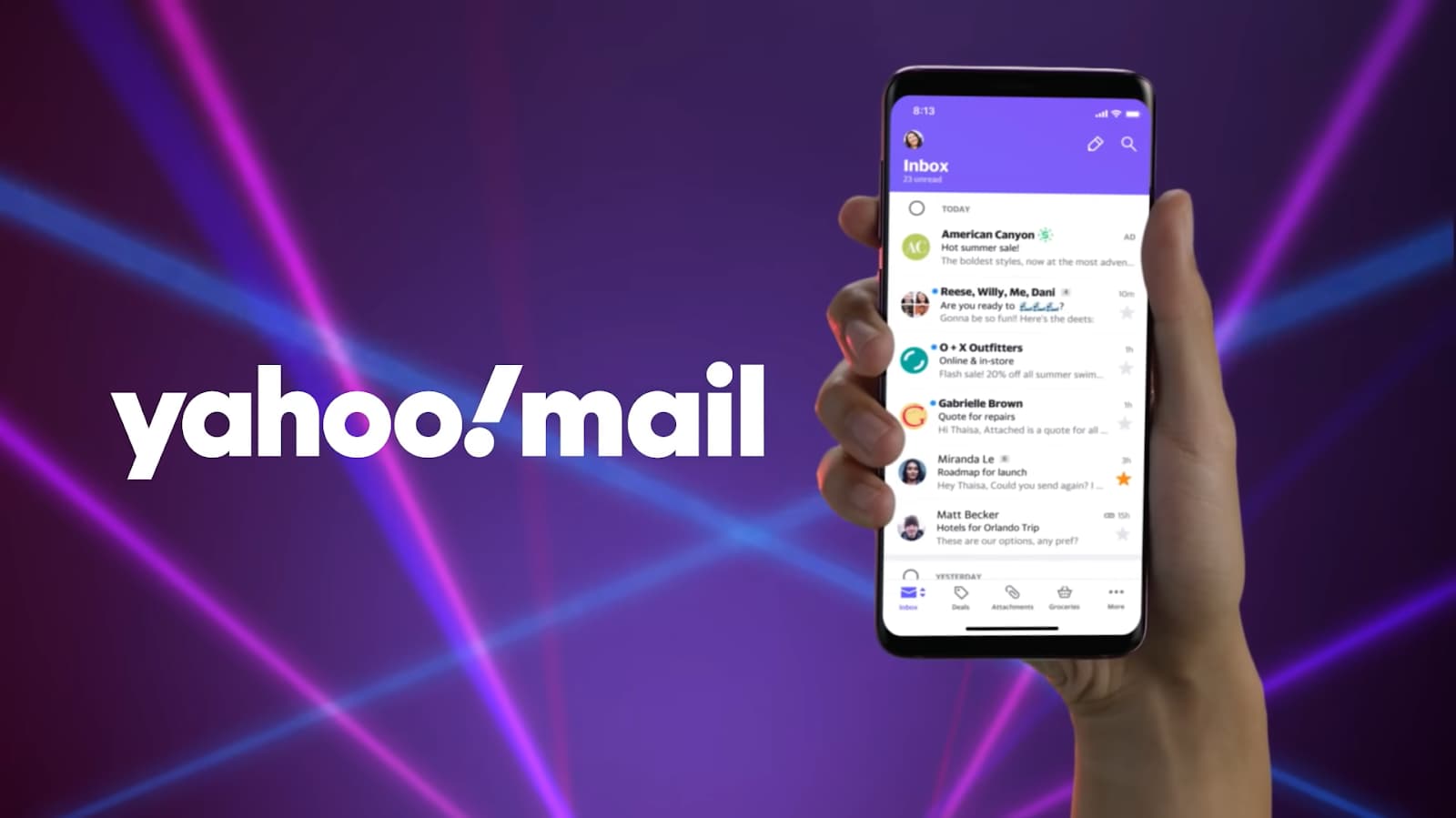 Hand holding a phone displaying the Yahoo Mail app inbox